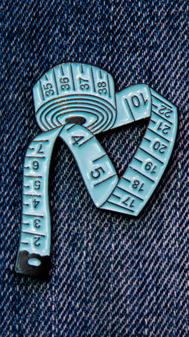 Pin's couture représentant un mètre ruban bleu.