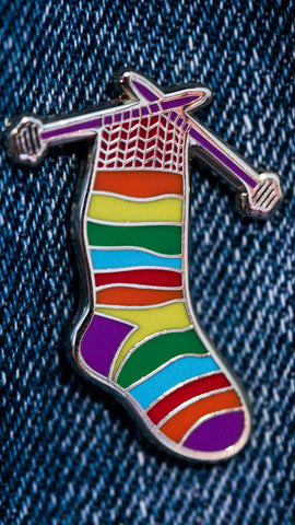 Pin's Chaussette multicolore en train d'être tricotée aux aiguilles