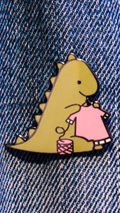 Pin's d'un dinosaure vert tricotant un pull rose